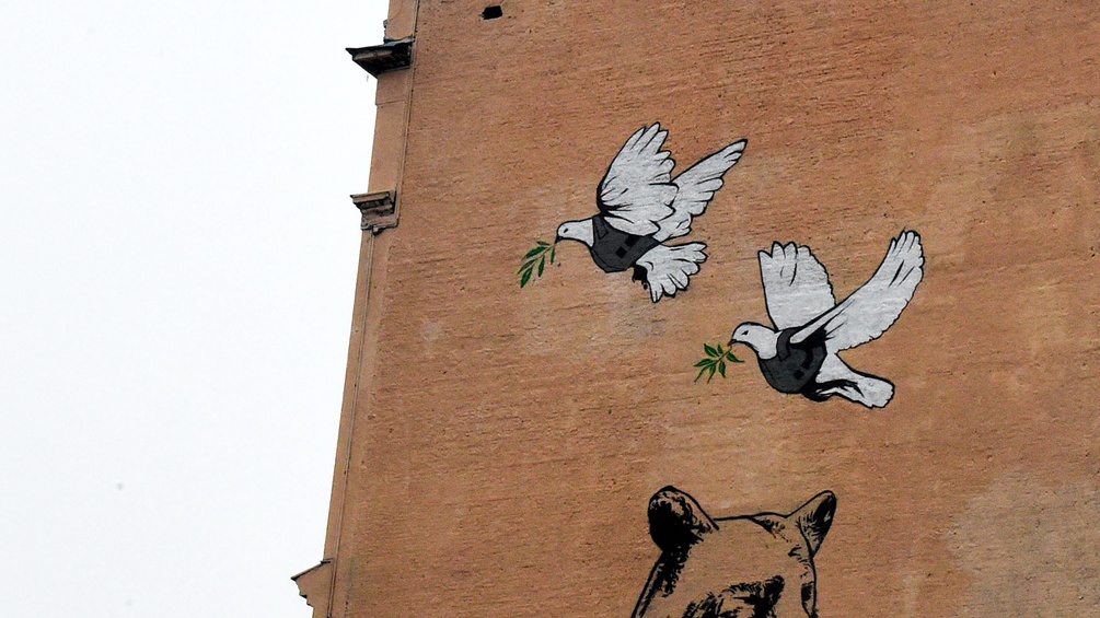 Gemalte Friedenstauben und ein Bär auf einer Hausmauer in Moskau