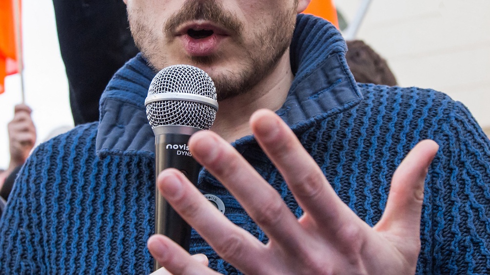 Mann spricht mit Mikrofon in der Hand