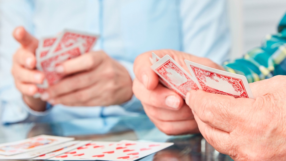 Alte Menschen spielen Karten
