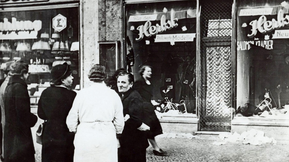 Passanten stehen im November 1938 in einer Stadt in Deutschland vor einem juedischen Geschaeft, dessen Schaufensterscheiben in der Reichskristallnacht am 9. Nov. 1938 zerstört wurden