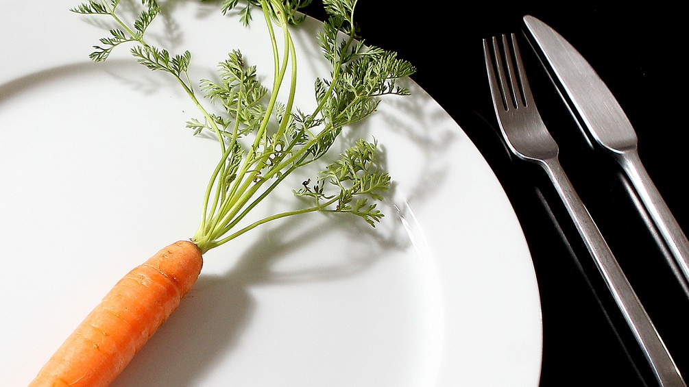 Karotte mit Besteck auf einem Teller
