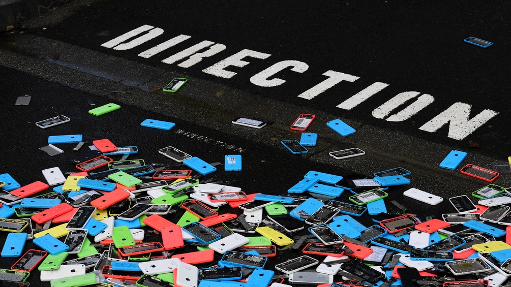 Handys liegen auf der Strasse, am Boden steht "Direction"