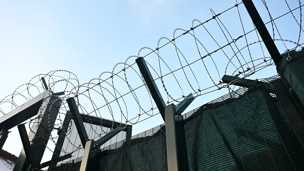 Stacheldraht entlang der Mauer einer Justizanstalt in Wien-Simmering
