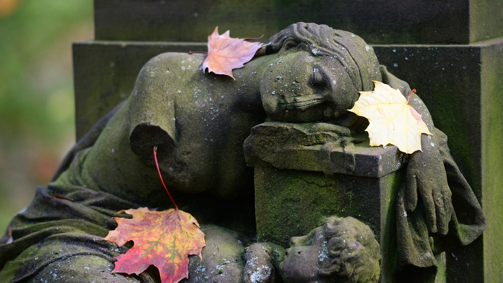 Eine Figur einer Dame liegt auf einem Grabstein