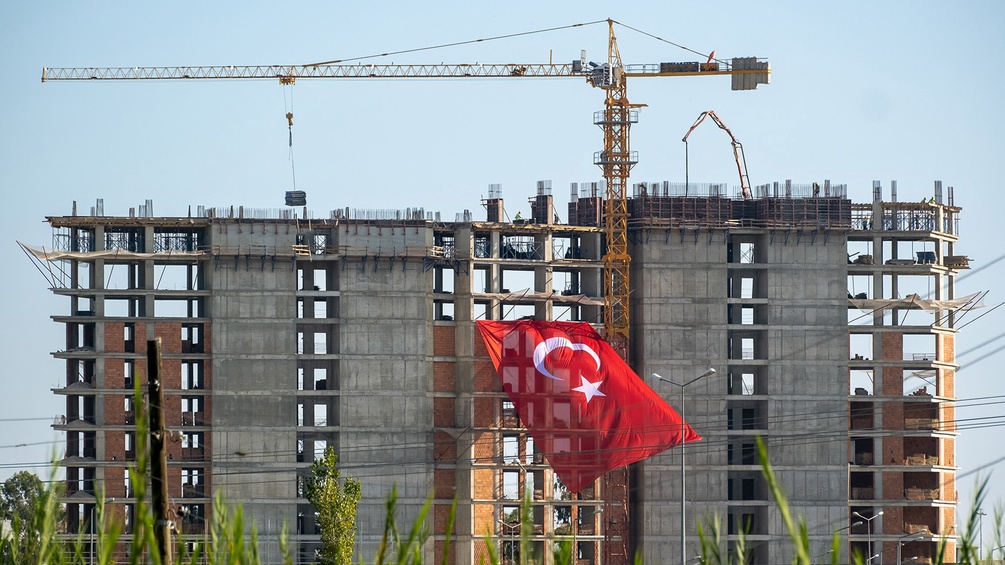 Baustellenstillstand eines Wohnungsbaus in der Türkei, türkische Flagge und Kran