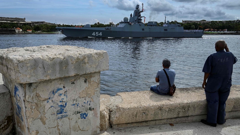 Zwei Männer stehen am Meer in Kuba