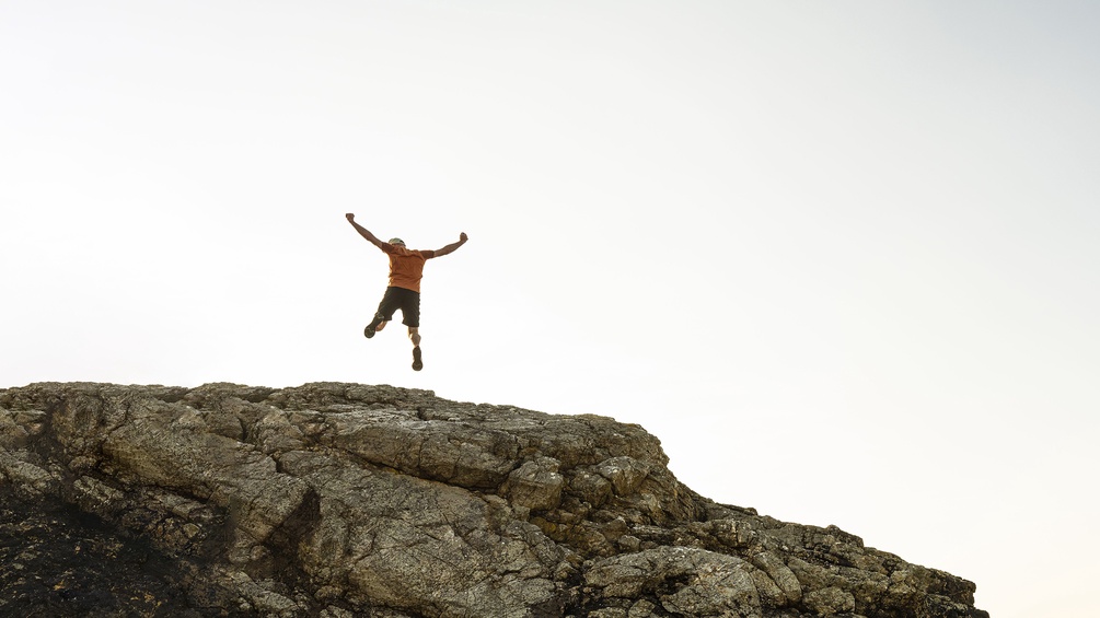 Mann springt von einer Klippe