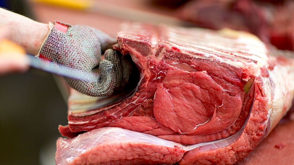 APA/KEYSTONE/GAETAN BALLY Fleischhauer bearbeitet ein Stück Fleisch