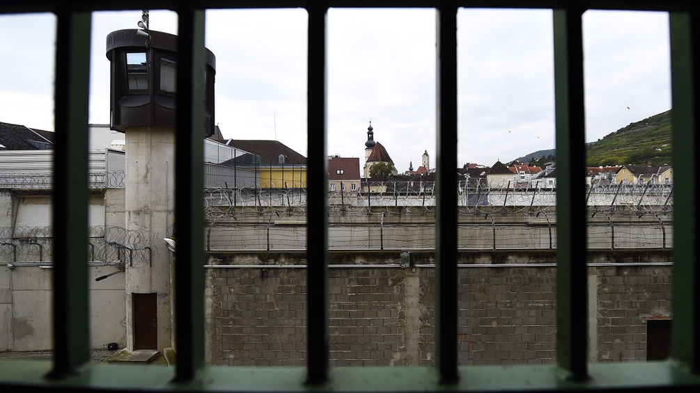Blick durch das vergitterte Fenster einer Gefängniszelle