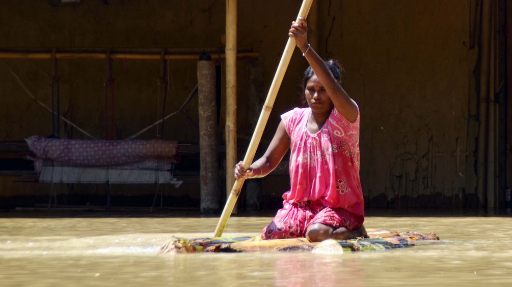 PICTUREDESK.COM/ZUMA/SIMANTA TALUKDAR Überschwemmung in Indien, Frau paddelt auf einem Floss