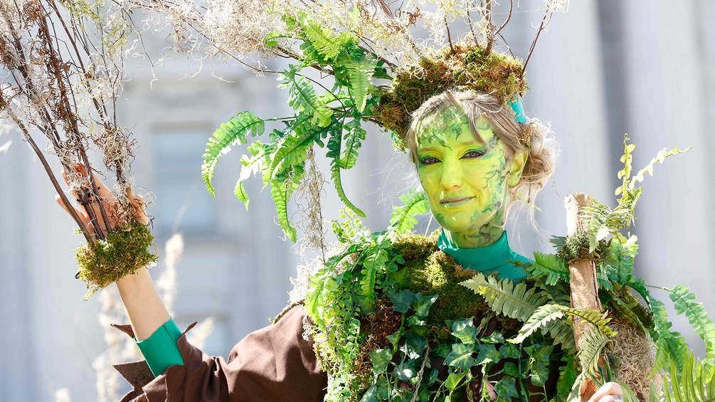 Eine Frau, die als Baum verkleidetet ist, protestiert im Rahmen des Klimagipfel in San Francisco