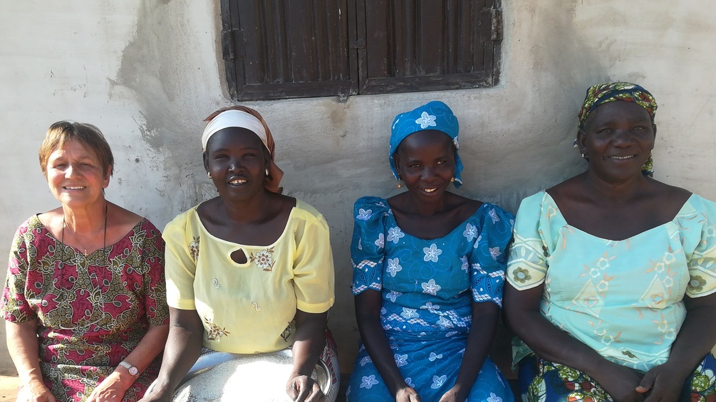 Die Autorin sitzt mit drei afrikanischen Frauen vor einem Haus.