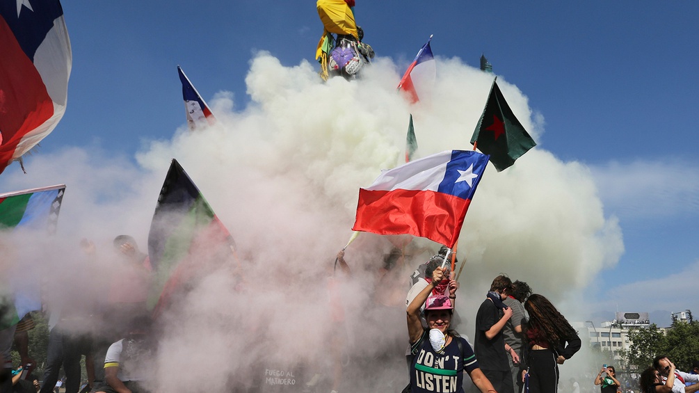 Rauch, Protestierende und die chilenische Fahne