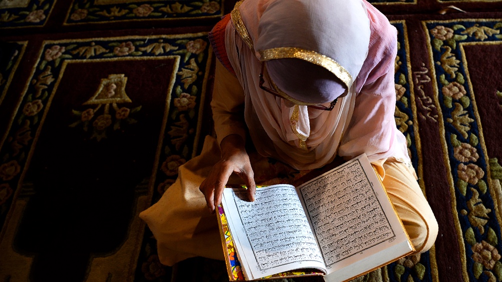Frau liest im Koran