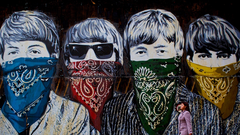 Die Beatles mit Tüchern vor dem Gesicht als Wandbild