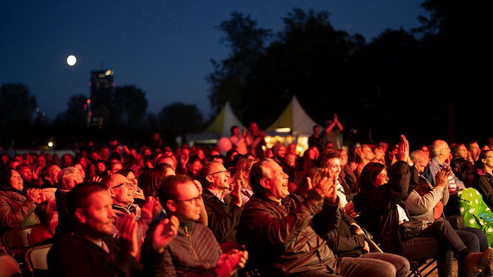 Menschen lachen am Donauinselfest 2021 vor der Ö1 Kulturbühne.