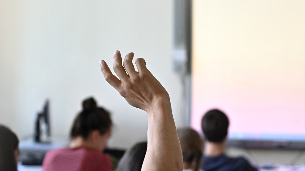 Eine Hand zeigt auf im Klassenzimmer