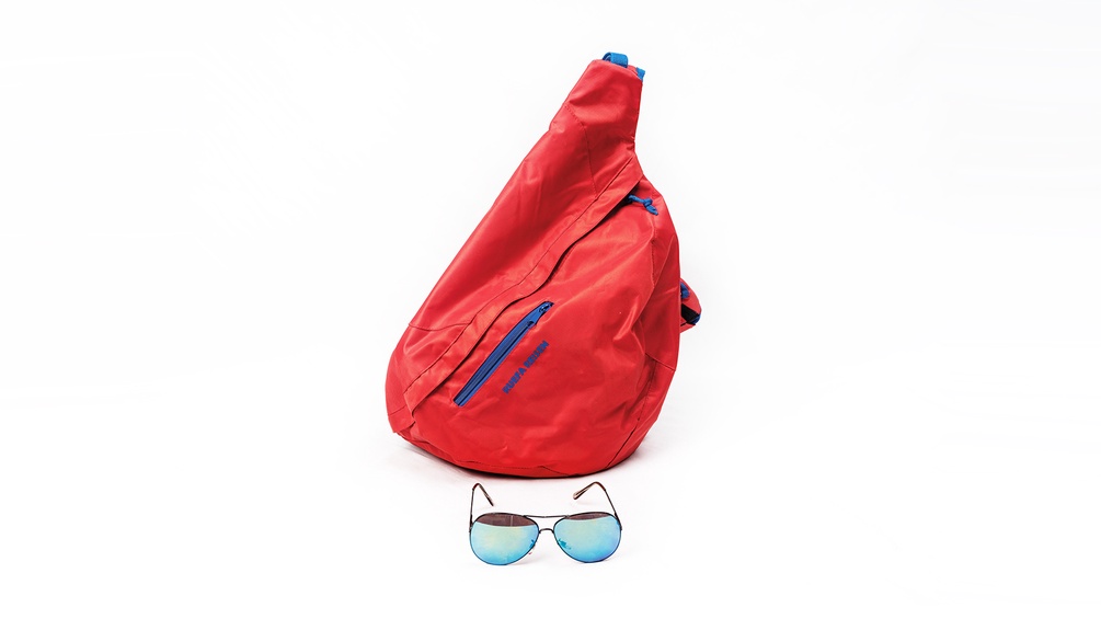 Ein roter Rucksack und eine Sonnenbrille