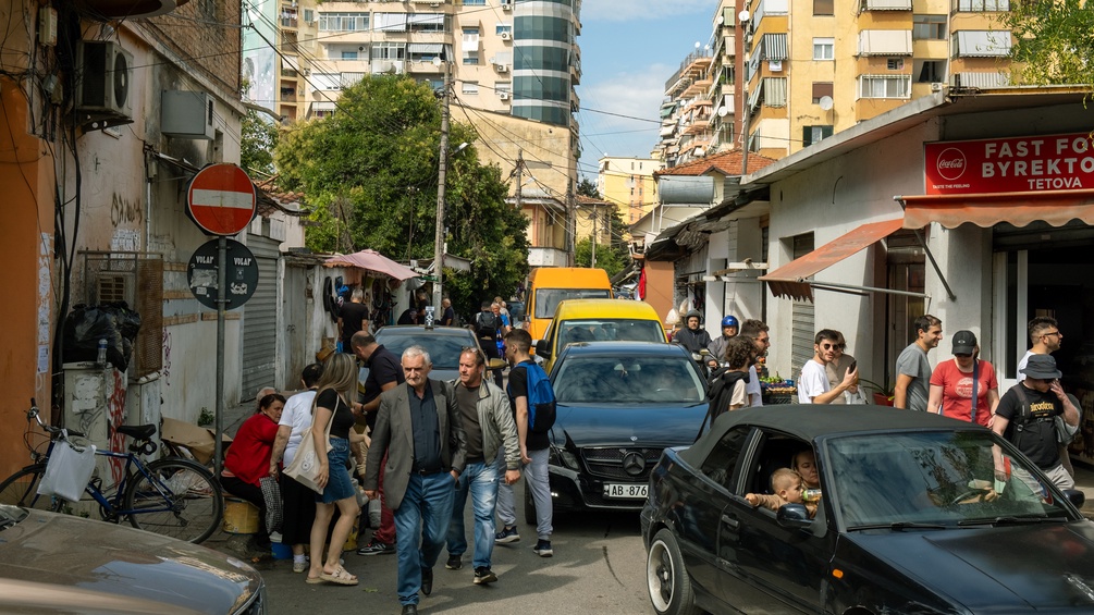 BASTIAN/CARO/PICTUREDESK.COM Auf einer Strasse in Tirana bewegen sich Menschen und Autos.