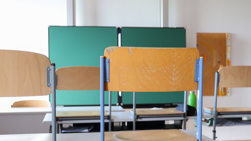 Klassenzimmer: Hochgestellte Stühle und Tafel