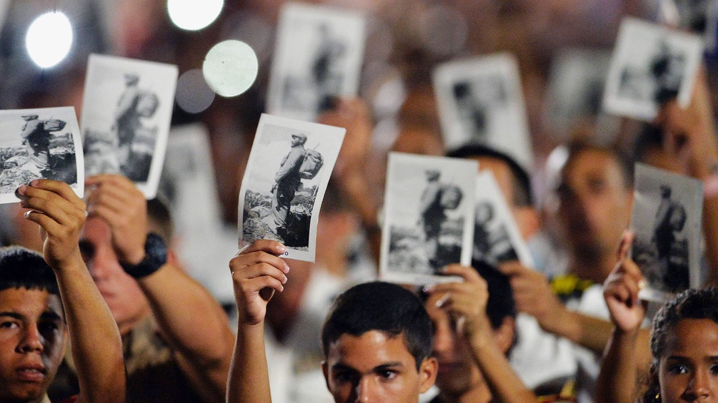 Menschen halten Fotos von Fidel Castro hoch