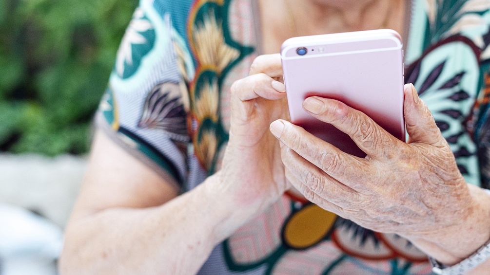 Ältere Dame hält ein Smartphone in Händen