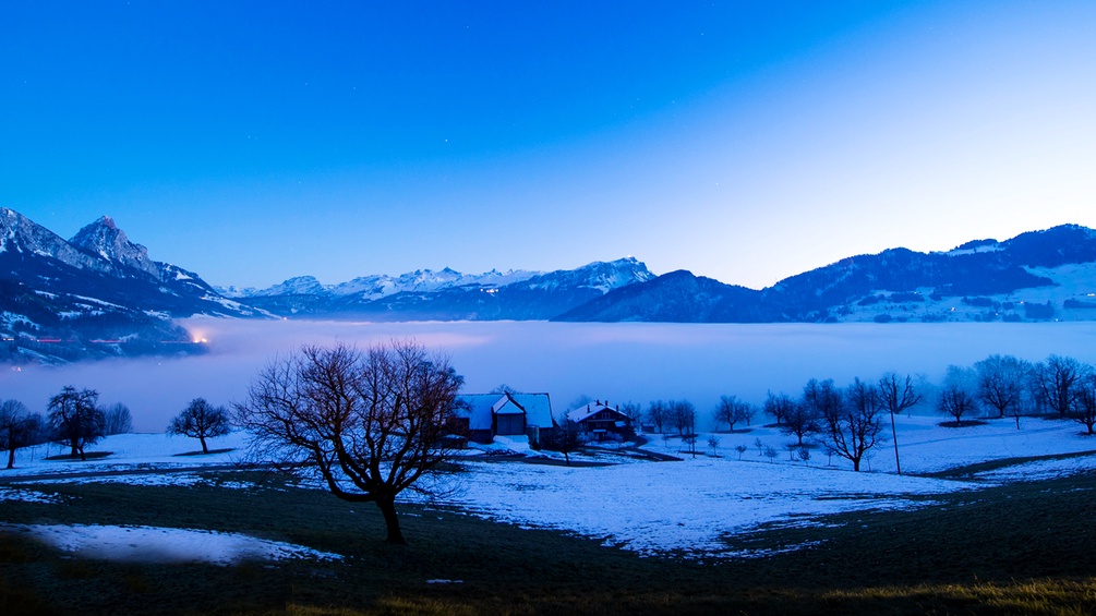 Vernebelte Landschaft mit den schweizer Alpen im Hintergrund