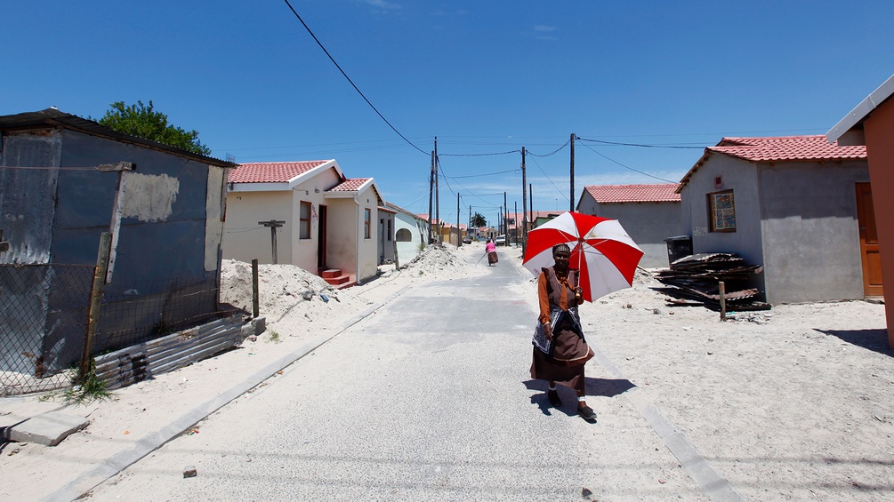 PICTUREDESK.COM/EPA/NIC BOTHMA Eine Frau mit Sonnenschirm im Township Kayelitsha