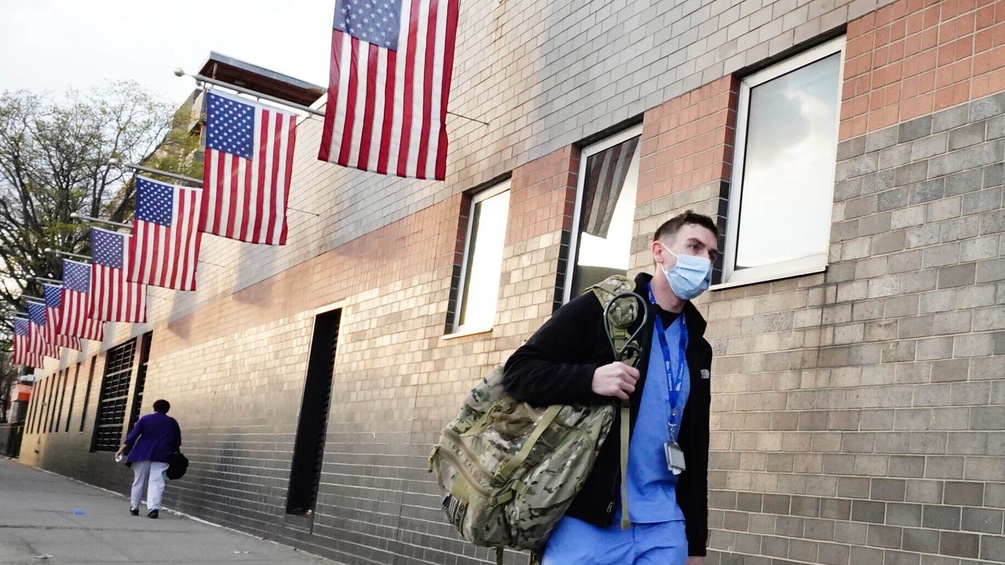 Ein Mann verlässt ein New Yorker Krankenhaus im Arbeitsgewand und Maske