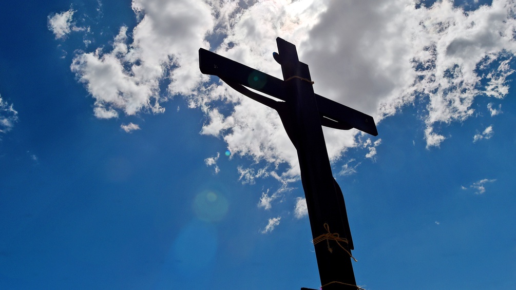 Ein Kreuz vor blauem Himmel