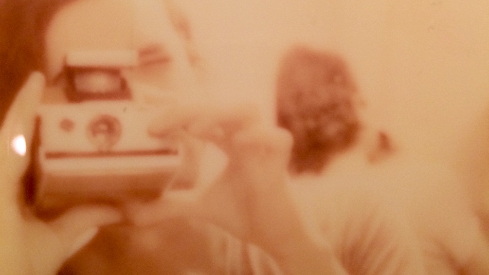 Ein analoges Bild von einer Frau mit einer Polaroid.