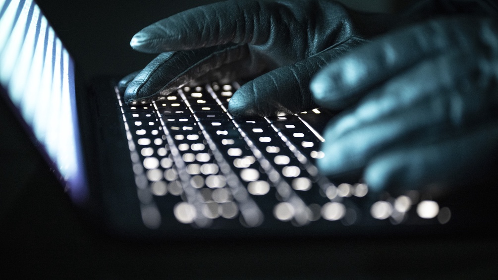 Hände in Handschuhen auf der Tastatur 