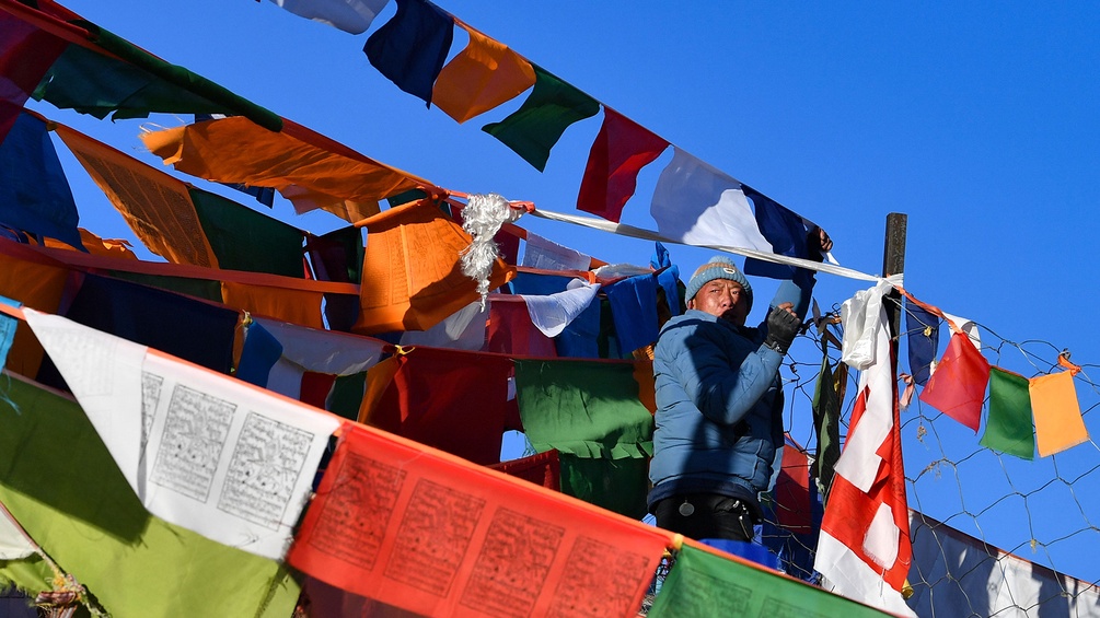 PICTUREDESK.COM/EYEVINE/JIGME DORJE XINHUA Mann in Tibet hängt Fahnen auf, tibetischer Mann