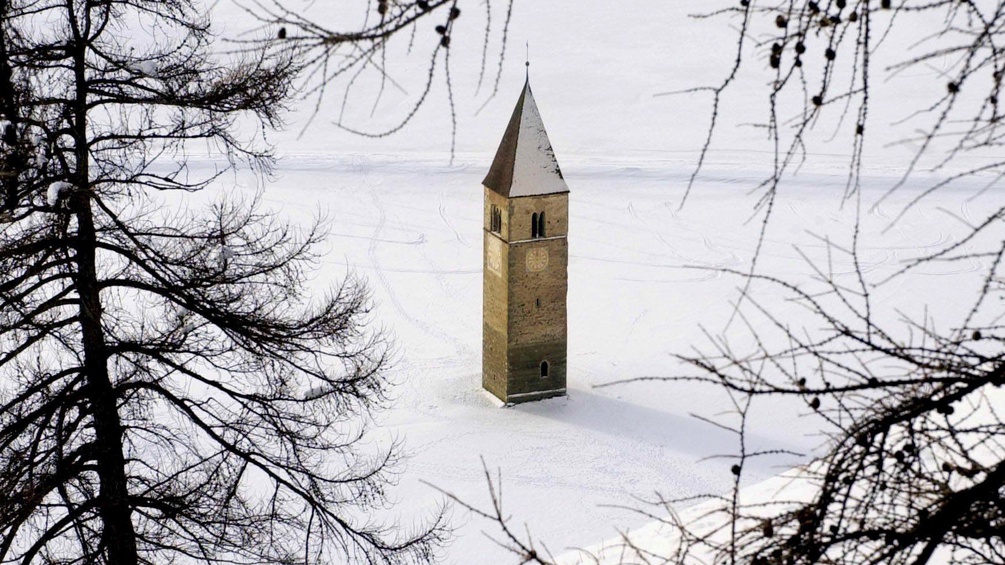 Kirchturmspitze im eingefrorenen See