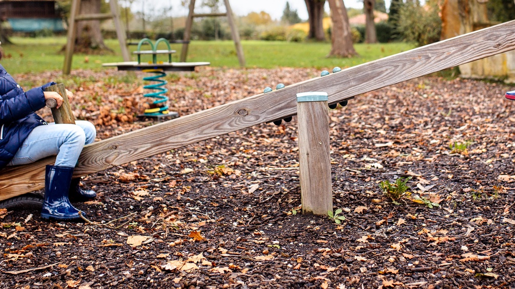 Kind auf einer Wippe, Spielplatz
