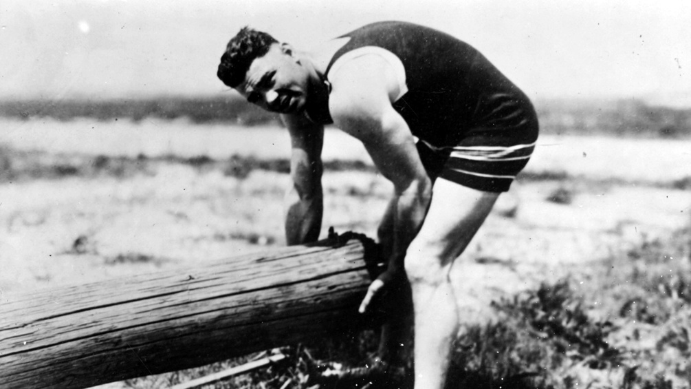 Boxer Jack Dempsey beim Training für die.Weltmeisterschaft: Heben eines.Baumstamms, um 1920