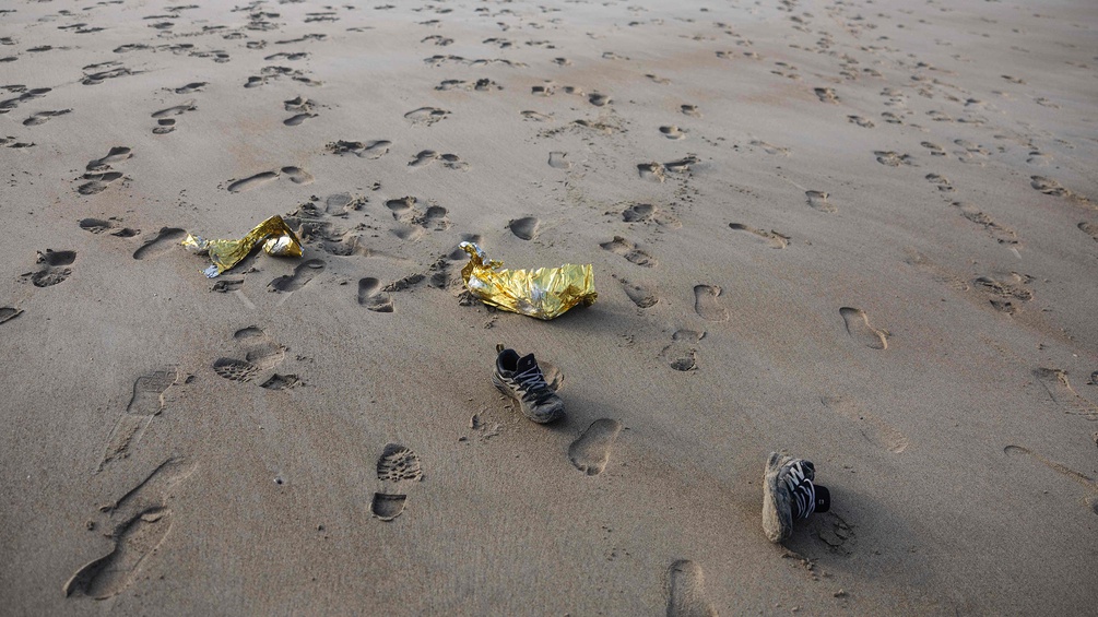 Schuhe und Spuren im Sand