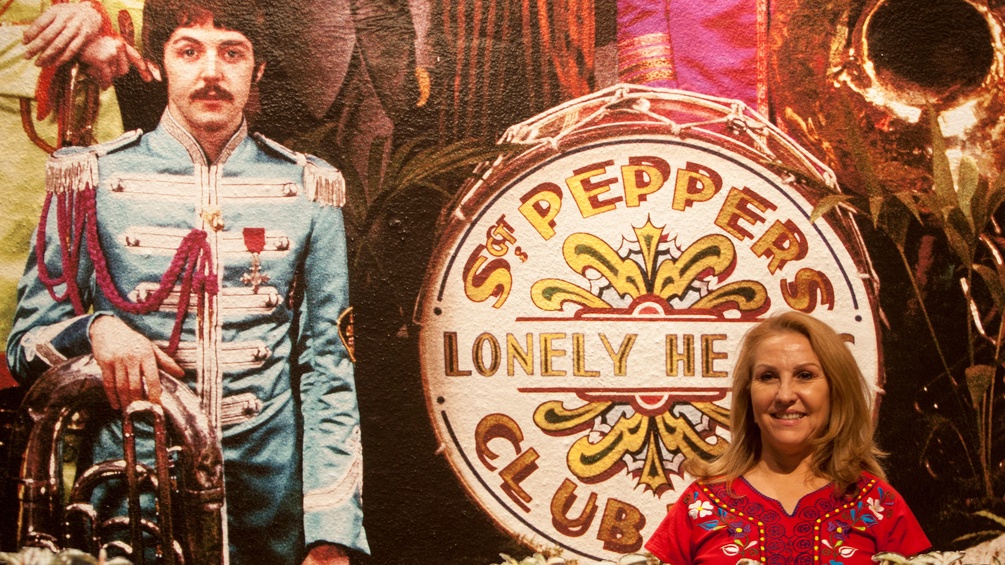 Eine Frau posiert vor dem Sgt.-Pepper-Cover der Beatles