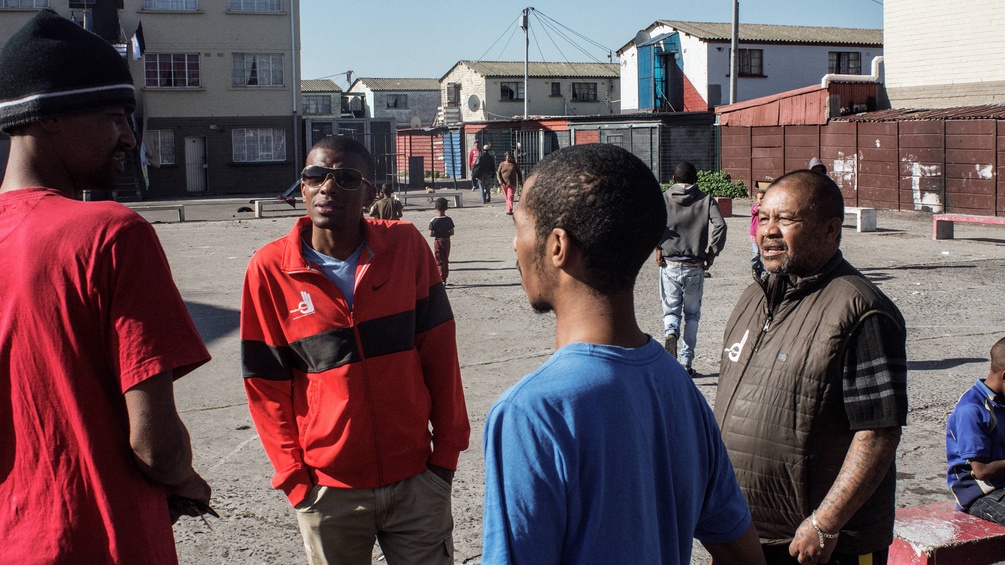 Sozialarbeite reden mit Gangmitgliedern in Südafrika.