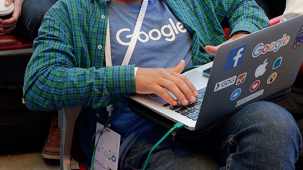 Mann mit Google-T-Shirt und Laptop