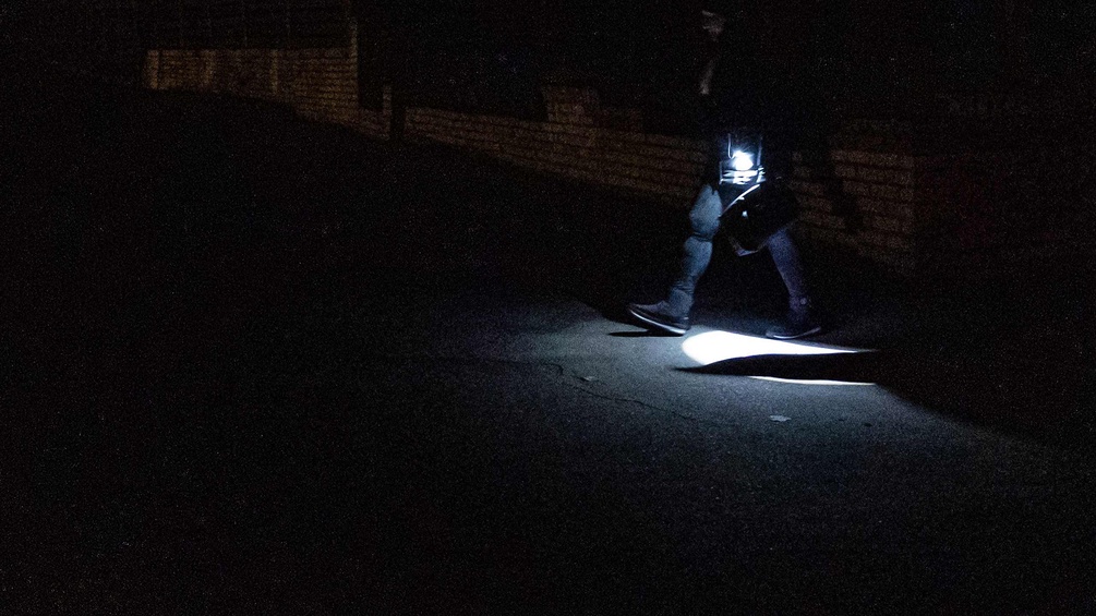 Person mit Taschenlampe in der Nacht