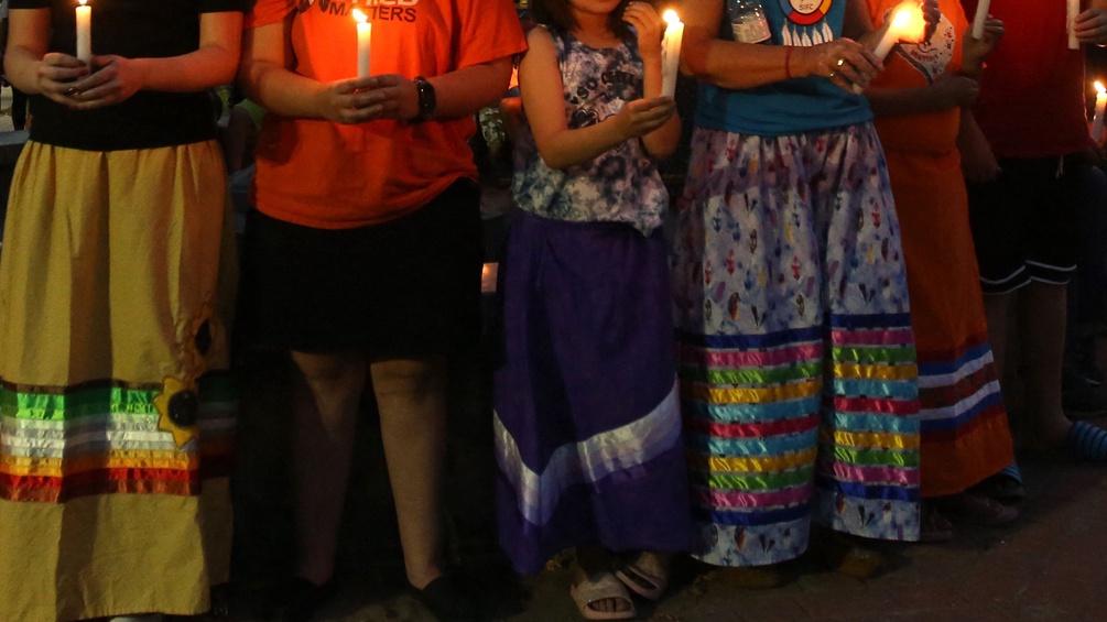 Indigene Frauen in Kanada halten Kerzen.