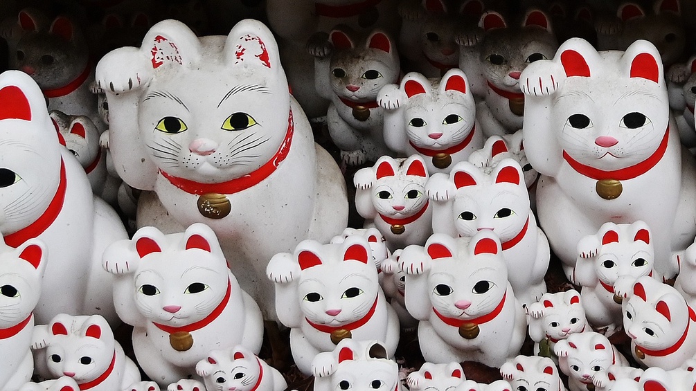 Viele weiße winkende Katzen Figuren aus der Vogelperspektive.