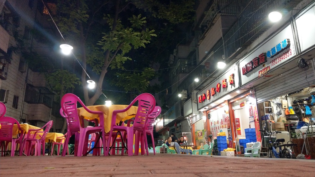 Rosa Plastikstühle neben Geschäften