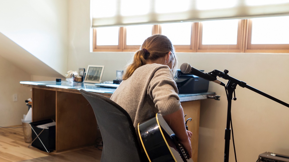 Eine Frau singt und spielt Gitarre