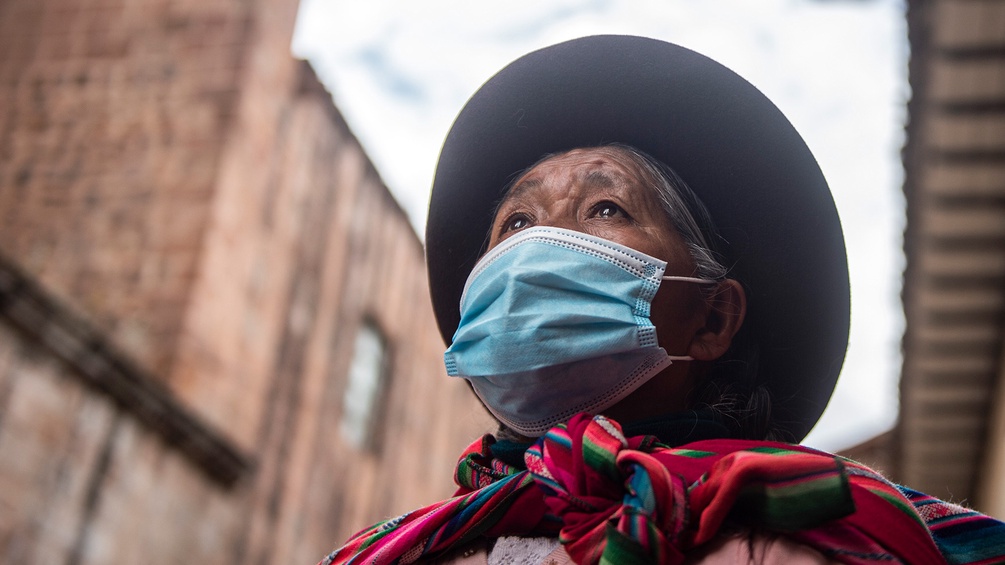Frau mit Mund-Nasen-Schutz und Hut in Cusco, Peru
