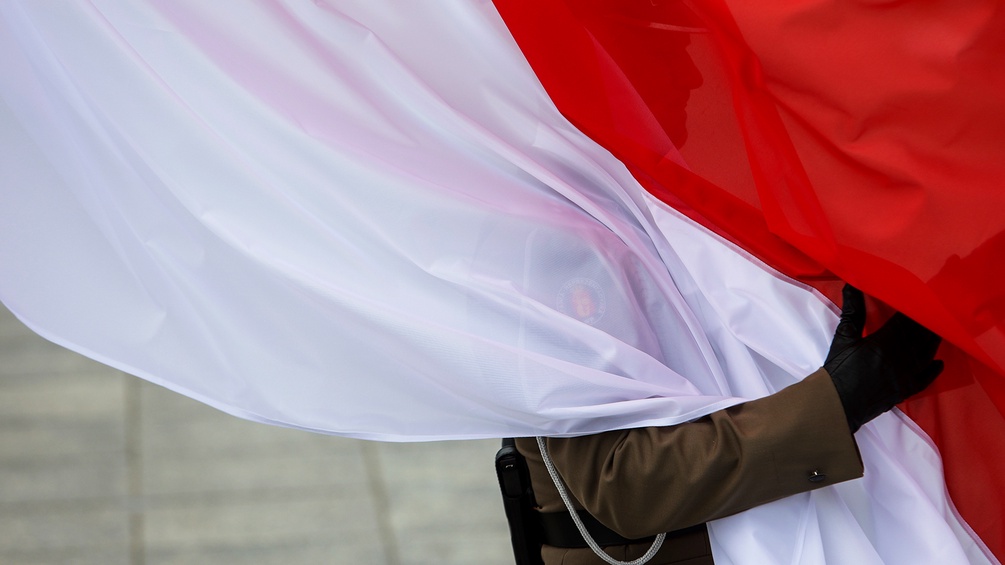 Arm hält polnische Flagge