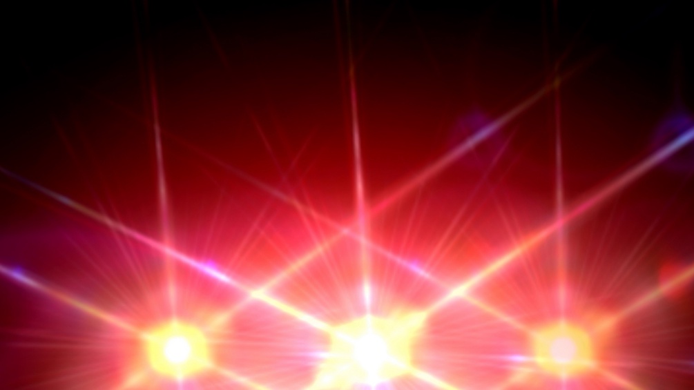 Bühnenlicht: Hell leuchtende Lichter, die rote und gelbe Strahlen mit Lens-Flare-Effekten aussenden