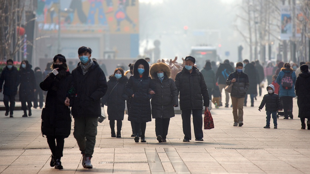 Menschen bummeln in Peking durch eine Fußgängerzone