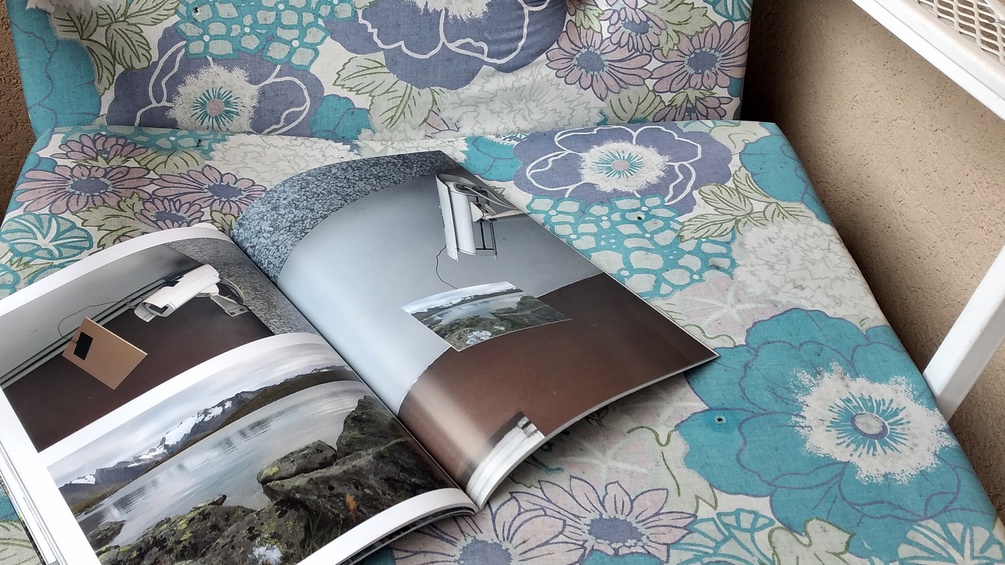 Aufgeschlagenes Buch auf Sitzpolster, florales Muster